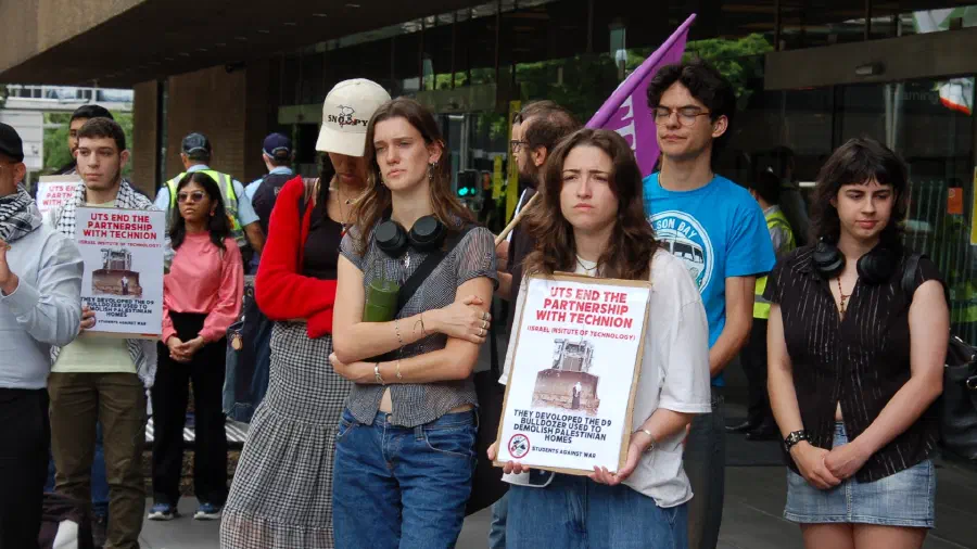 Protestors hold placards outside UTS Sydney.