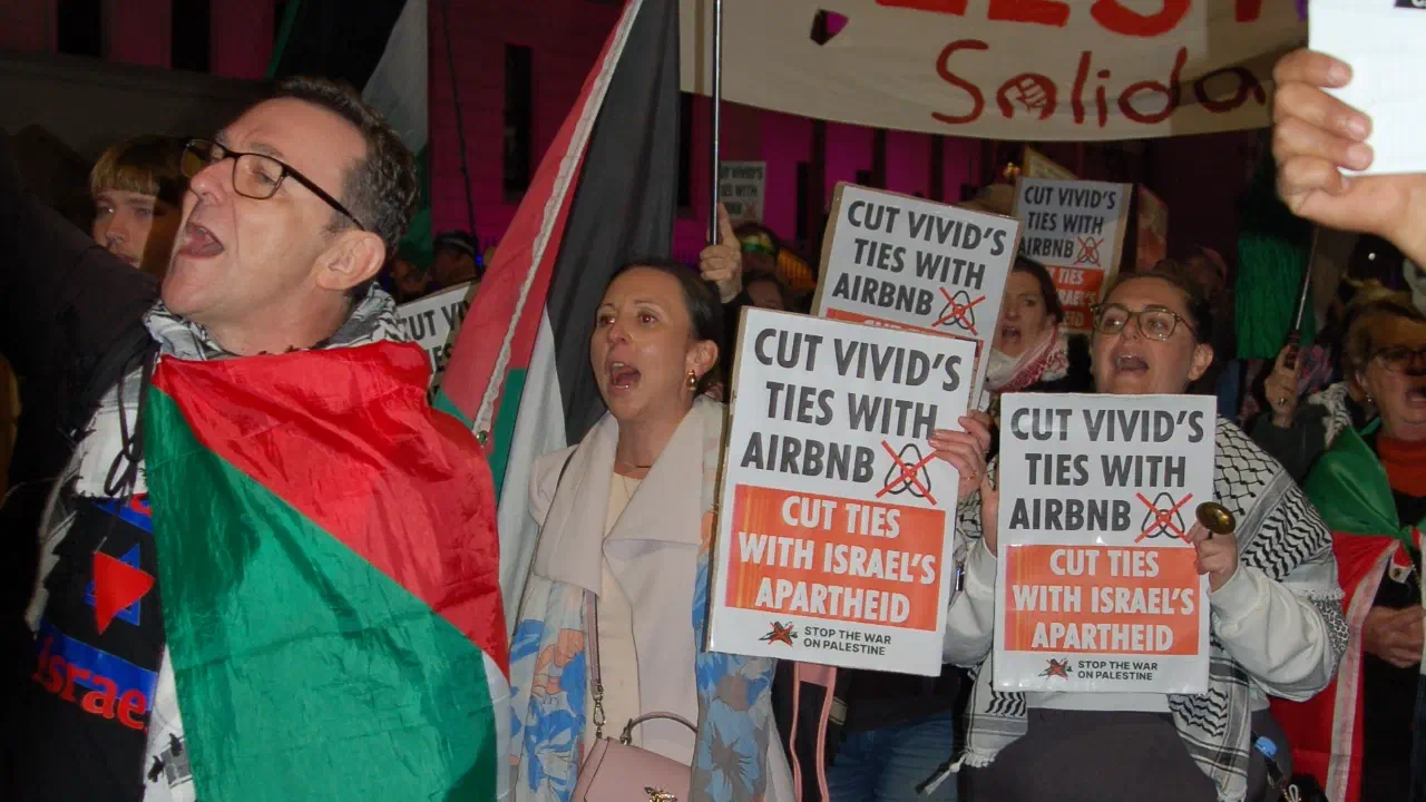 Protestors march through Sydney holding placards with the text: Cut Vividʼs ties with Airbnb.